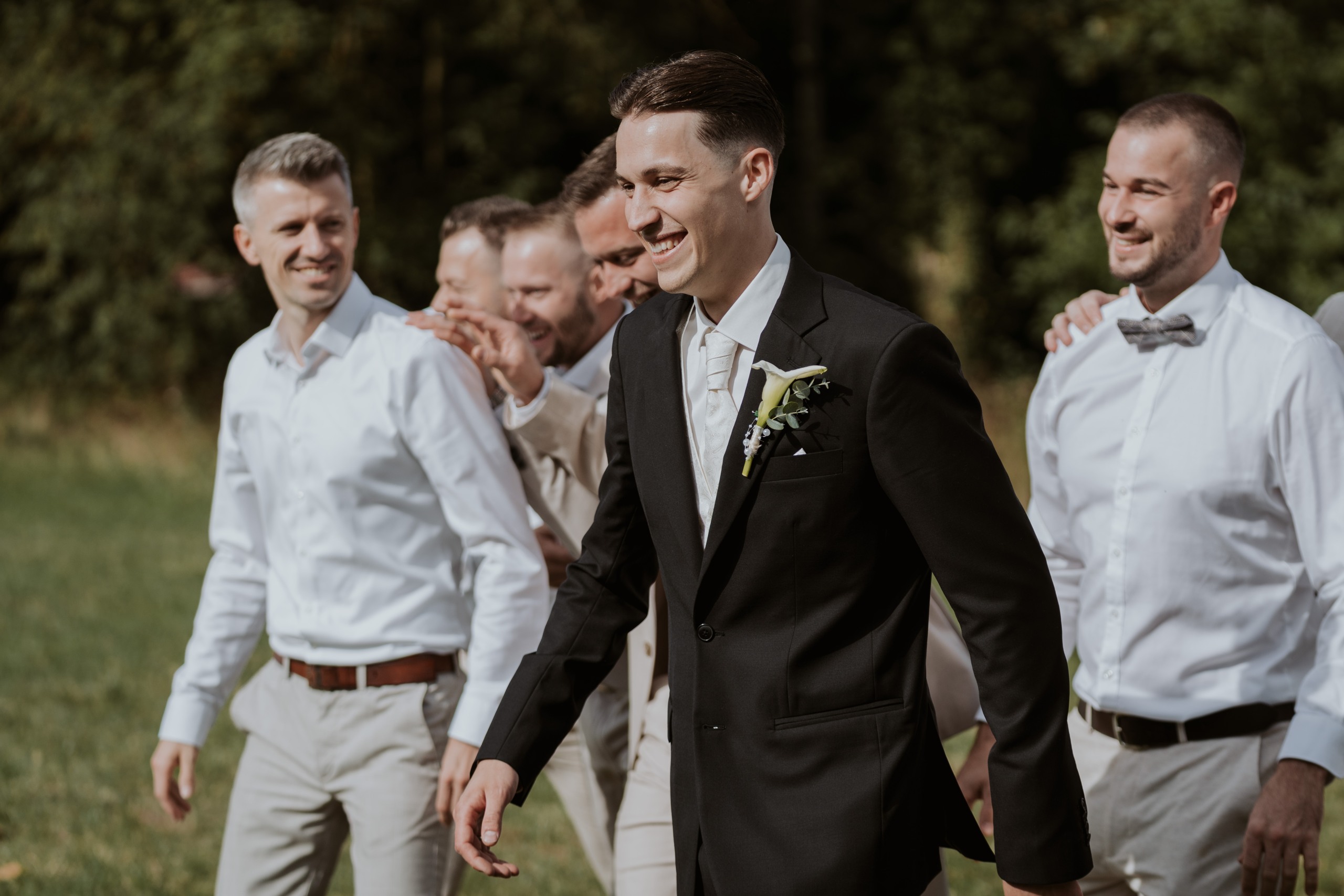 David lacht mit seinen Freunden am Hochzeitstag.