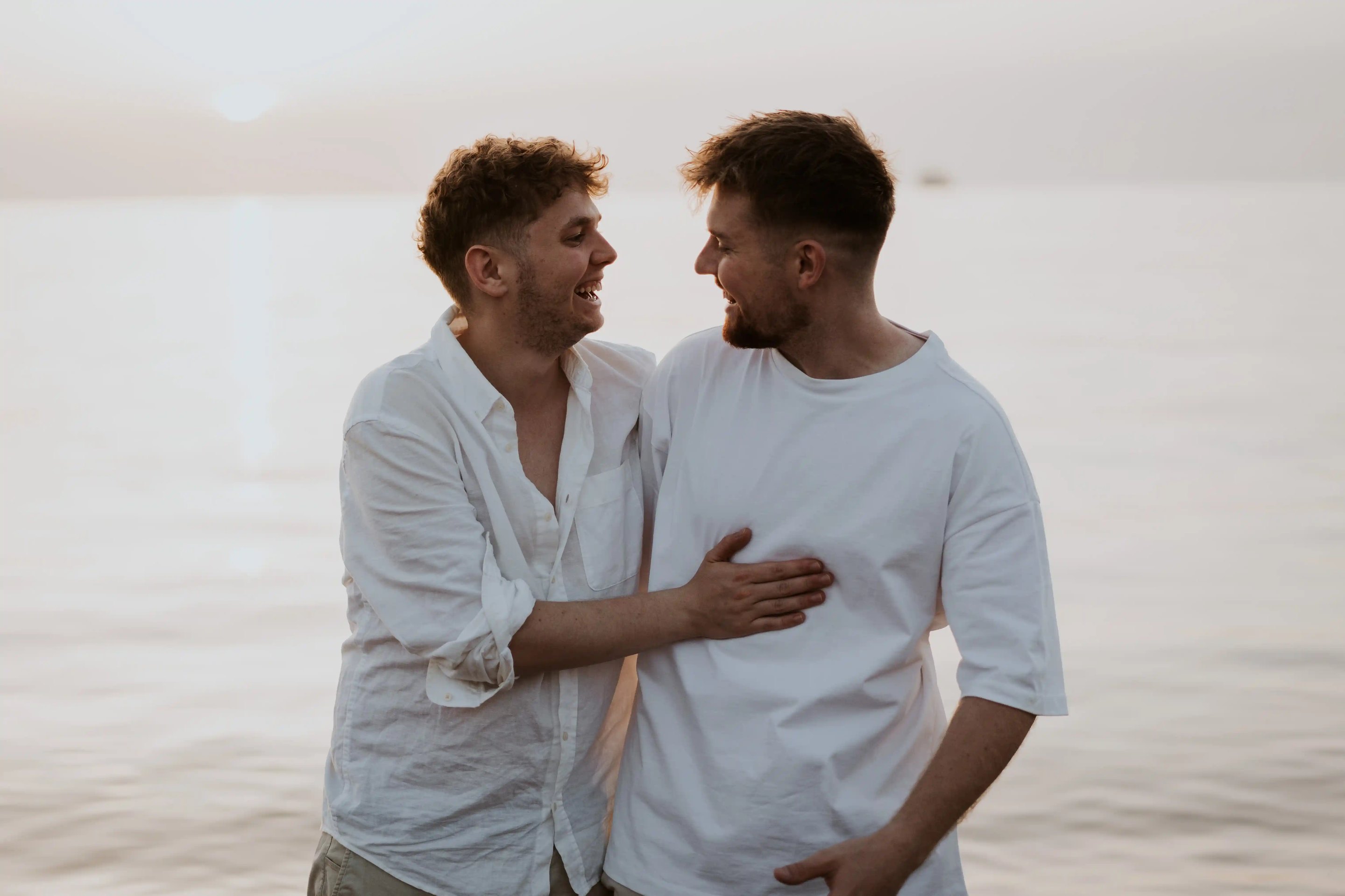 Luis und Sebastian lachen sich am Wasser an.