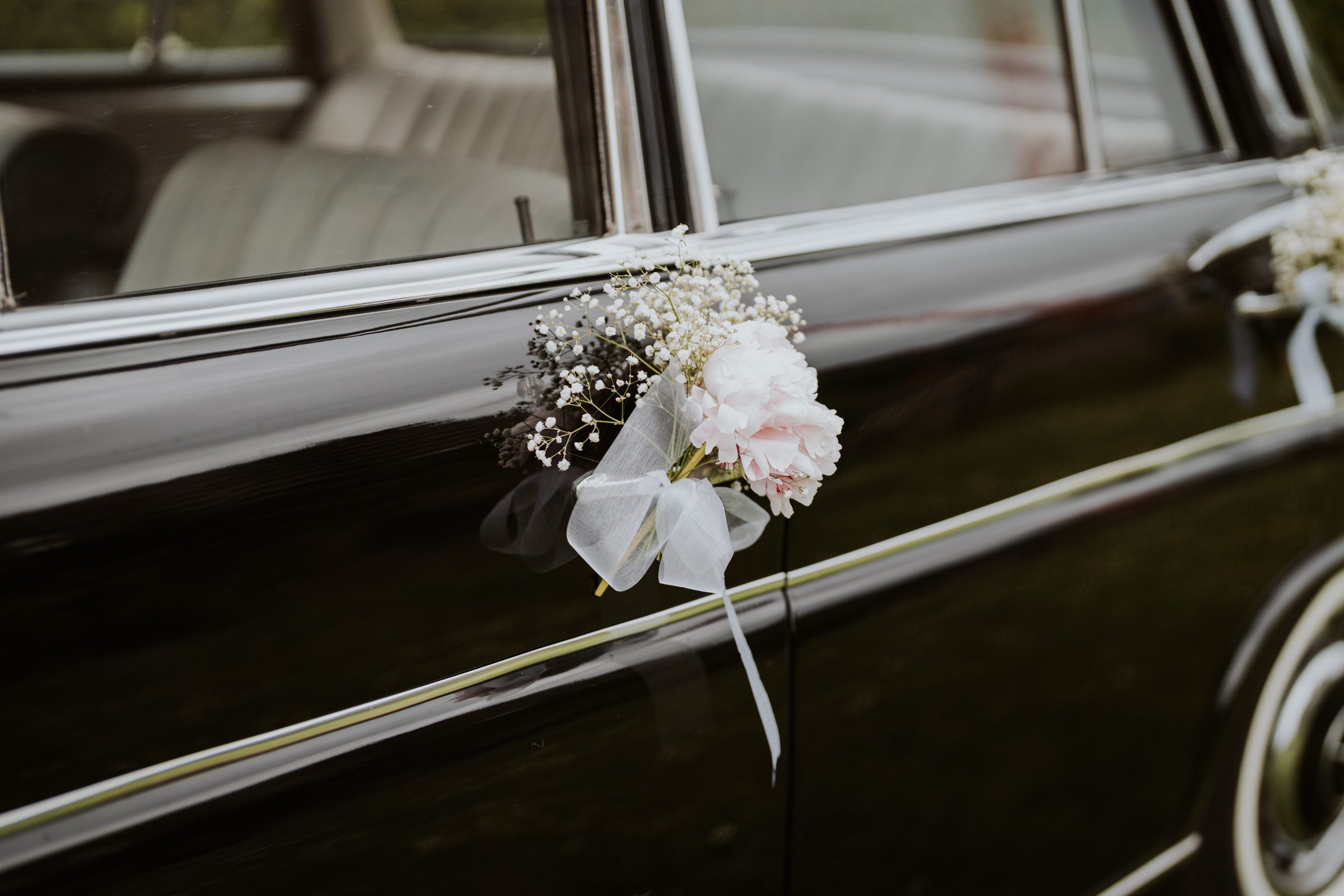 Blumen an einem historischen Hochzeitsauto.