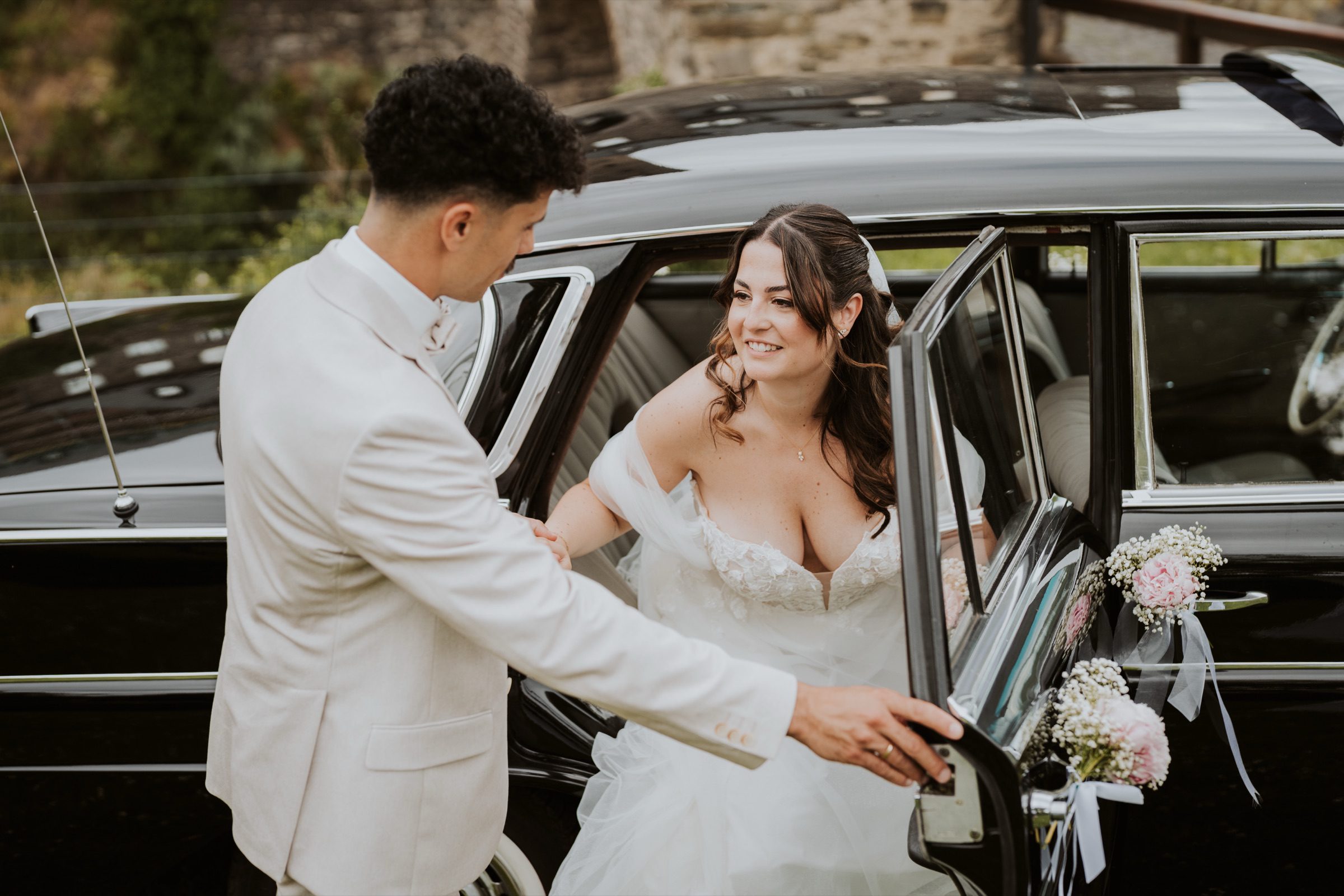 Ein Brautpaar am Hochzeitsauto.