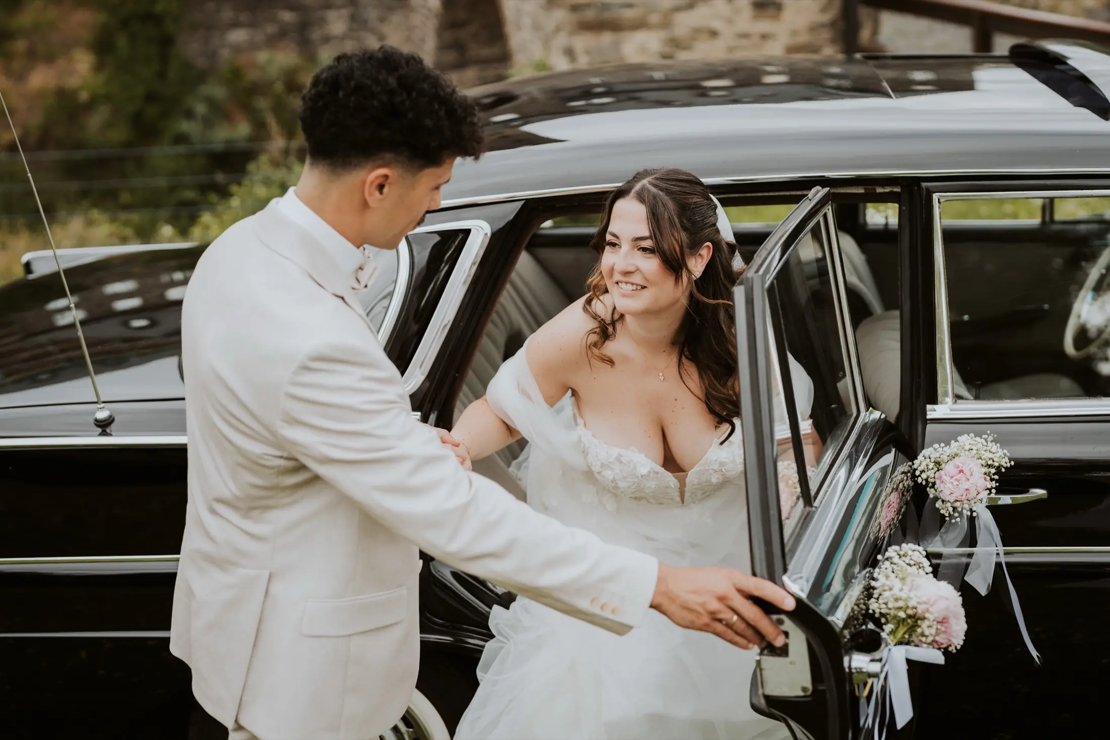 Ein Brautpaar am Hochzeitsauto.